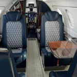 Салон Embraer Phenom 300E с клубными креслами и раскладным столом